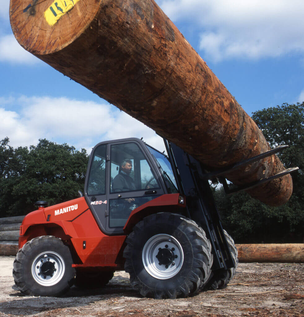 Rough terrain forklift carrying large piece of lumber