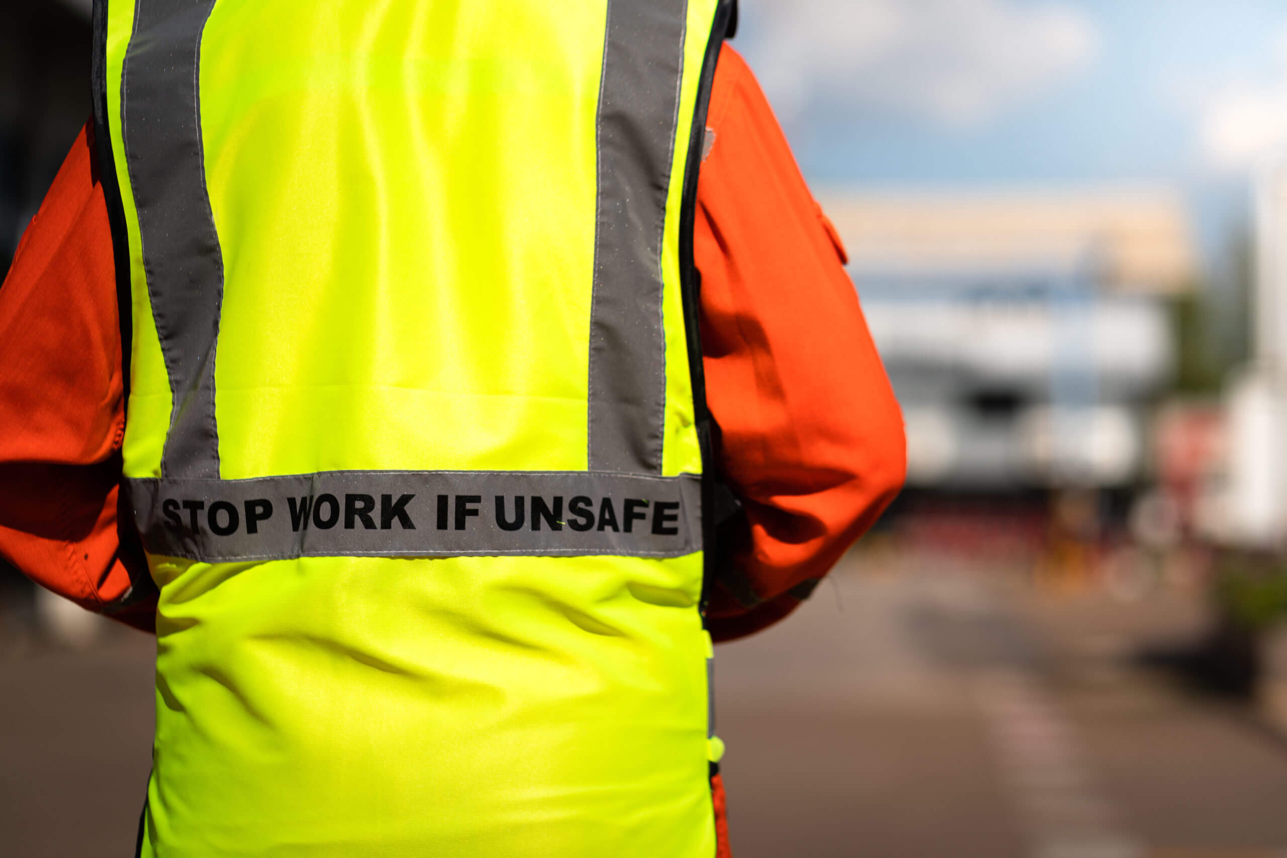 "Stop work if unsafe" on lifting reflective vest.