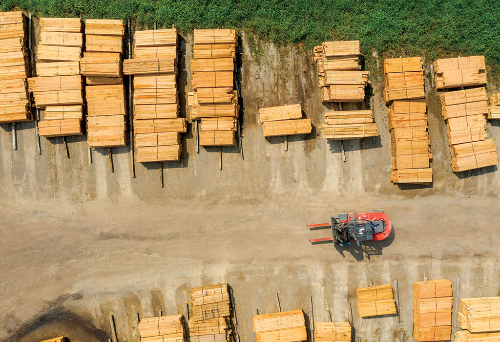 An aerial view of a lumberyard with organized stacks of timbers